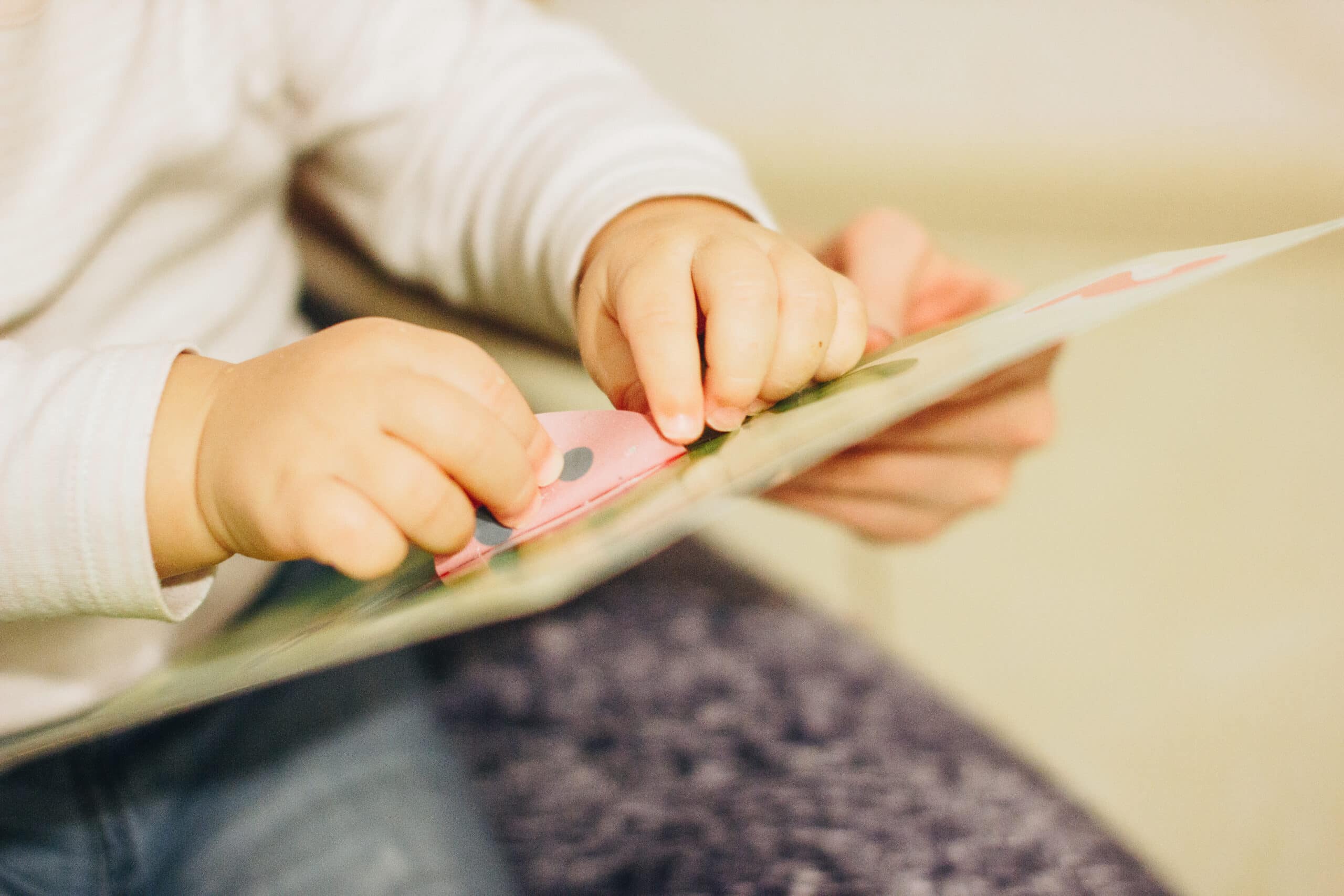 A toddler baby playing with stickers Toddler using stickers